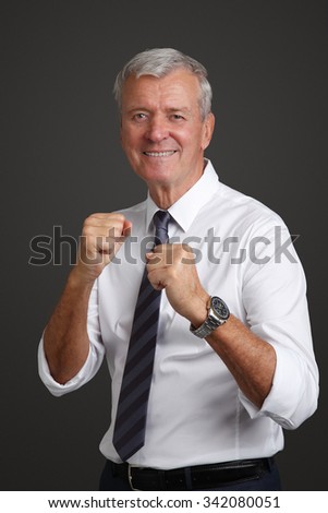 Close-up portrait of senior businessman boxing while standing against isolated background. 