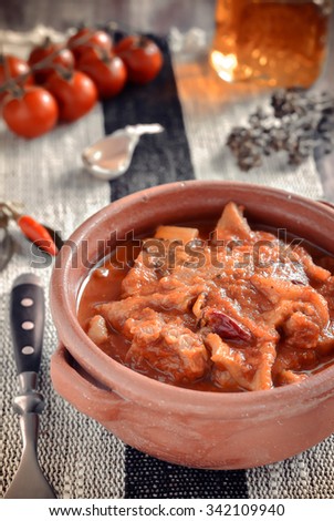 Beef Tripe Soup with tomatoes, spicy chili, oregano in a ceramic bowl on a wooden table. Italian food. 