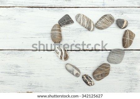 A heart shaped pebble stones on a old wood planks 
