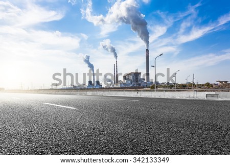 Wide angle landscape photograph of a road leading to a power plant
