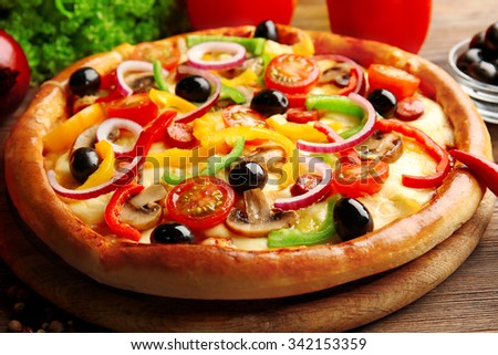 Delicious pizza with vegetables, on wooden table, close-up