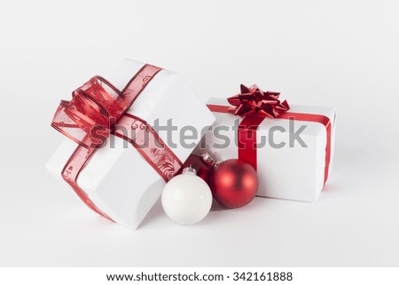 White Christmas presents with red ribbons and bow, red and white Christmas balls, isolated on white background