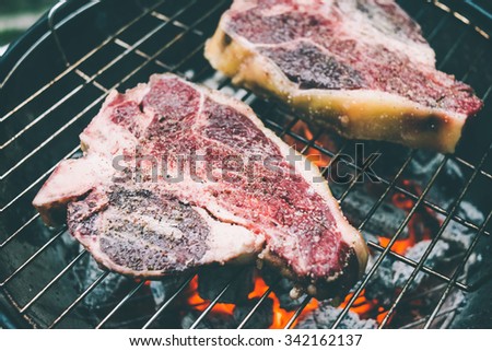 Two t-bone florentine beef steaks on the grill. Toned picture