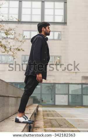 Portrait of a young handsome Indian man posing in an urban context