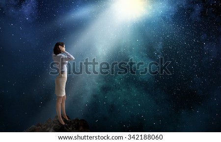Young woman covering her ears with hands and looking in night sky 