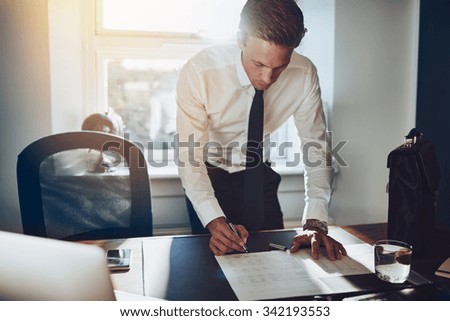 Business man standing at desk working on documents, white shirt and tie, male executive Royalty-Free Stock Photo #342193553