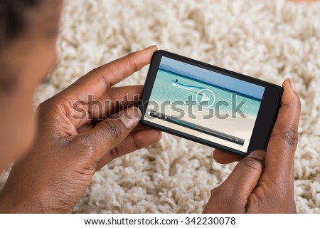 Close-up Of Person Watching Video On Mobile Phone