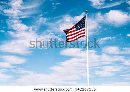 American flag waving under a blue sky