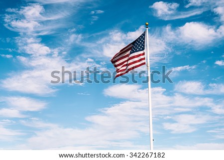 American flag waving under a blue sky