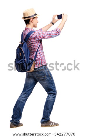 Travel concept. Studio portrait of handsome young man taking photo by his phone camera. Isolated on white.
