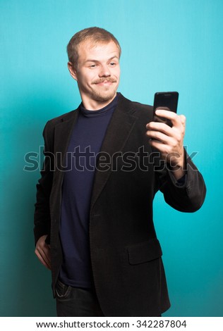 successful business man making funny self image, with a beard and mustache, office style studio photo isolated on a blue background
