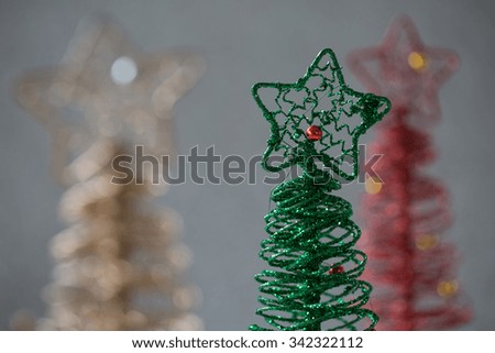 A close up view of a delightful arrangement of three wire Christmas trees with a silver sparkling background for a festive scene that would be enjoyable for many various ideas. horizontal format