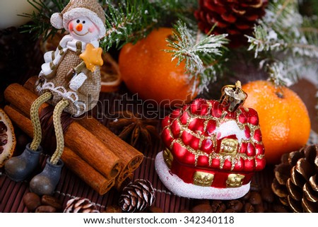 Xmas or new year composition with holiday decoration - sliced dried oranges and mandarin on wooden background with spruce twigs. Little man figures. Christmas card