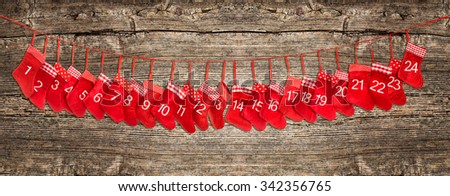 Advent calendar 1-24. Red christmas stocking decoration on rustic wooden background. Holidays festive banner