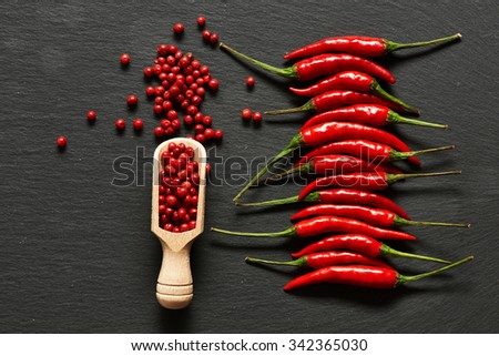 Red hot chili peppers and rose pepper on slate background 