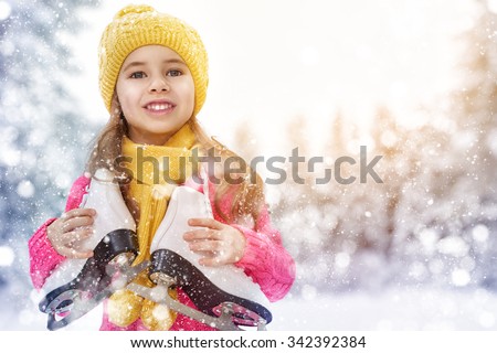 cute little girl is going skate outdoors