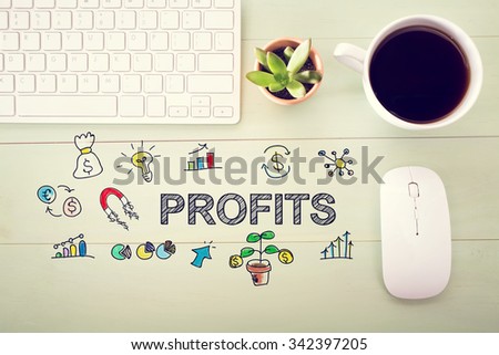 Profits concept with workstation on a light green wooden desk
