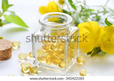 supplement in a bottle with evening primrose flowers Royalty-Free Stock Photo #342422183