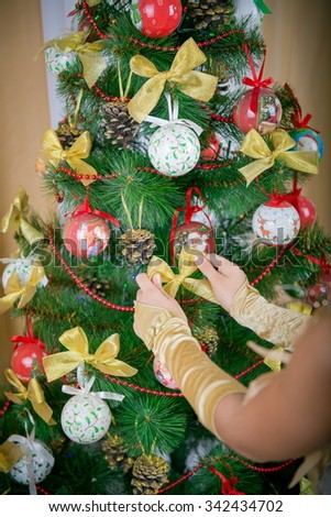 decorating a Christmas tree. girl's hands with gloves decorate the Christmas tree