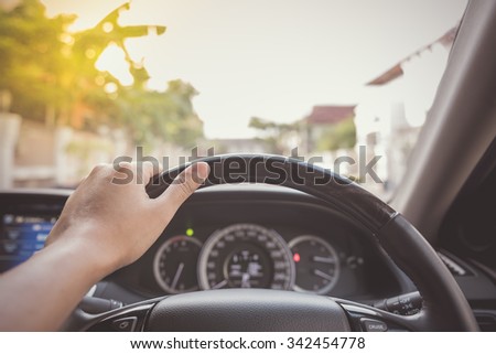 hand of driver on steering wheel of car - vintage picture style