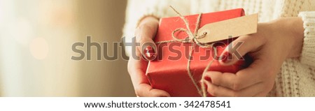 Girl holding red box of christmas present