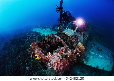 Underwater photography. Photographer diver scuba take a photo of Japanese sea plane, shot down during World War II. Actual under water Photo. 50 meters depth. Japan sea, Far East
