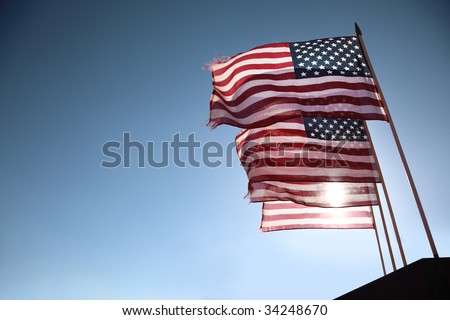 Four American flags waving over blue sky