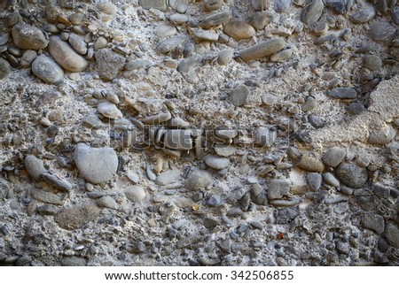 Photo closeup outdoor of gray old pebble stone wall facade exterior of rocks of various sizes and forms on mural background, horizontal picture