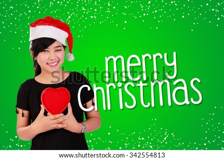Green Christmas card background design composition with image of nice smiling Asian girl holding a heart sign