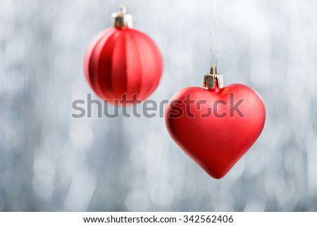 Red Xmas decorations on silver bokeh background. Merry Christmas and Happy New Year card