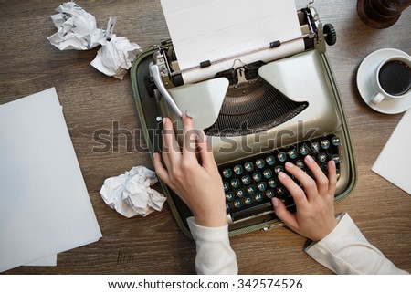 Vintage typewriter and blank sheet of paper, human hands