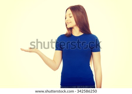 Teenage woman showing something on open hand.