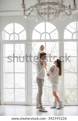 Portrait of happy young parents with baby  at home.