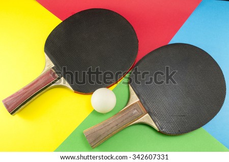 Pair of table tennis paddles on a colorful collage background