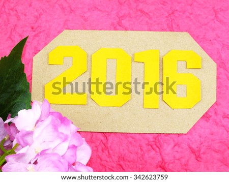 happy new year concept decoration with artificial flower on pink background