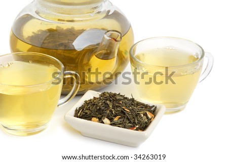 Tea leaves with two cups of tea and teapot on white background