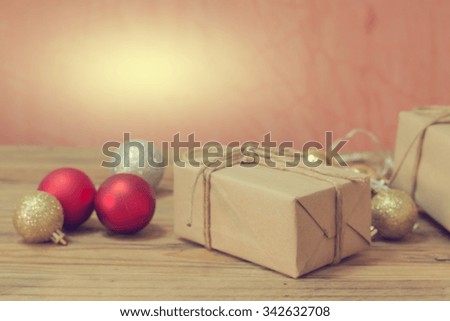 Gift boxes and christmas balls on wooden table brick color background. christmas balls red, silver, and gold. motion blur image vintage style.