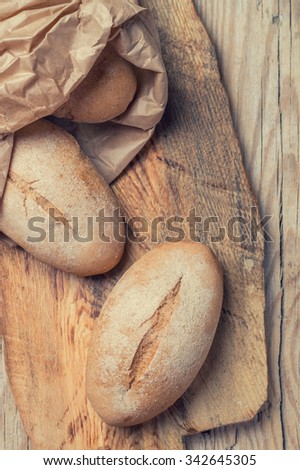 freshly baked bread with bran on a wooden background. top view