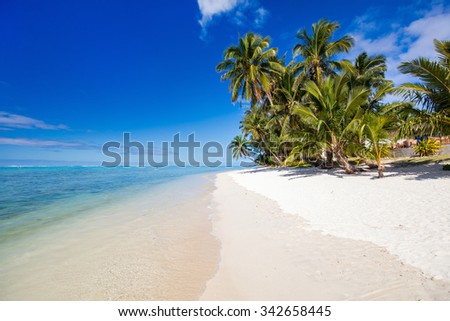 Beautiful tropical beach with palm trees, white sand, turquoise ocean water and blue sky at Cook Islands, South Pacific Royalty-Free Stock Photo #342658445
