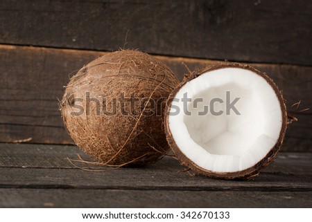 Ripe half cut coconut on a wooden background. Ripe half cut coconut on a wooden background