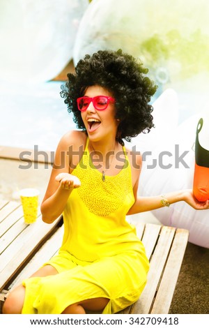 Party concept,woman send kiss with red lips,Eyewear concept.Portrait of a funny hipster girl with trendy glasses and drink alcohol cocktails.Vintage soft image.Duck face emotion.Close up.Indoor shot