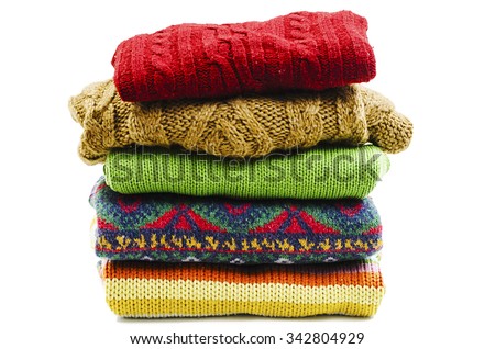 Stack of various sweaters. Winter style. Isolated on white background