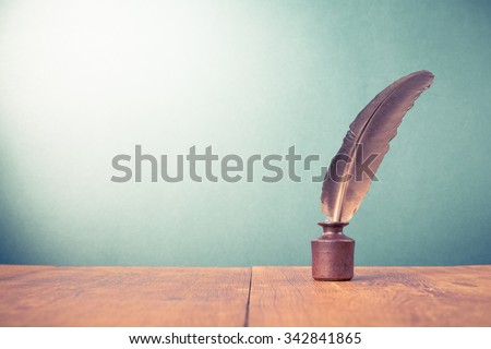 Vintage old quill pen with inkwell on wooden table. Retro style filtered photo Royalty-Free Stock Photo #342841865