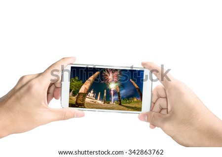Holding smart phone take a photo of old temple in Sukhothai with firework on white background