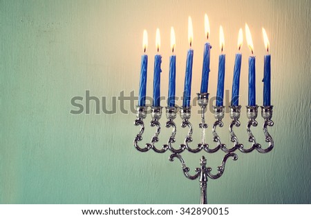 abstract retro filtered low key image of jewish holiday Hanukkah with menorah (traditional Candelabra). with glitter overlay
