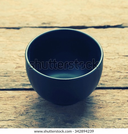 ceramic bowl on wooden background - vintage filter.