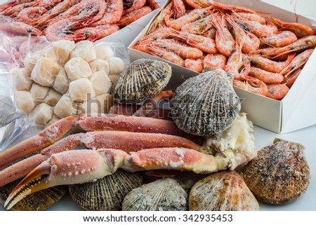 frozen shrimp in a box Frozen crab claws shell scallop shell and cleaned sea scallop Royalty-Free Stock Photo #342935453