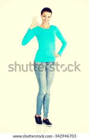 Full length woman showing ok sign.