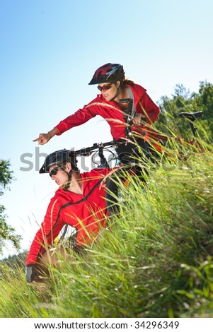 Man and woman with mountain bikes in a meadow