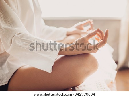 Young woman meditating at home. Beautiful fit girl doing exercises, practicing yoga. Harmony, balance, meditation, yoga practice, relaxation at home, healthy lifestyle concept Royalty-Free Stock Photo #342990884